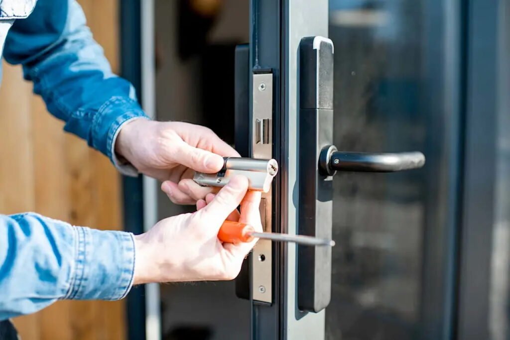 Professional locksmith repairing and installing a uPVC door lock system.